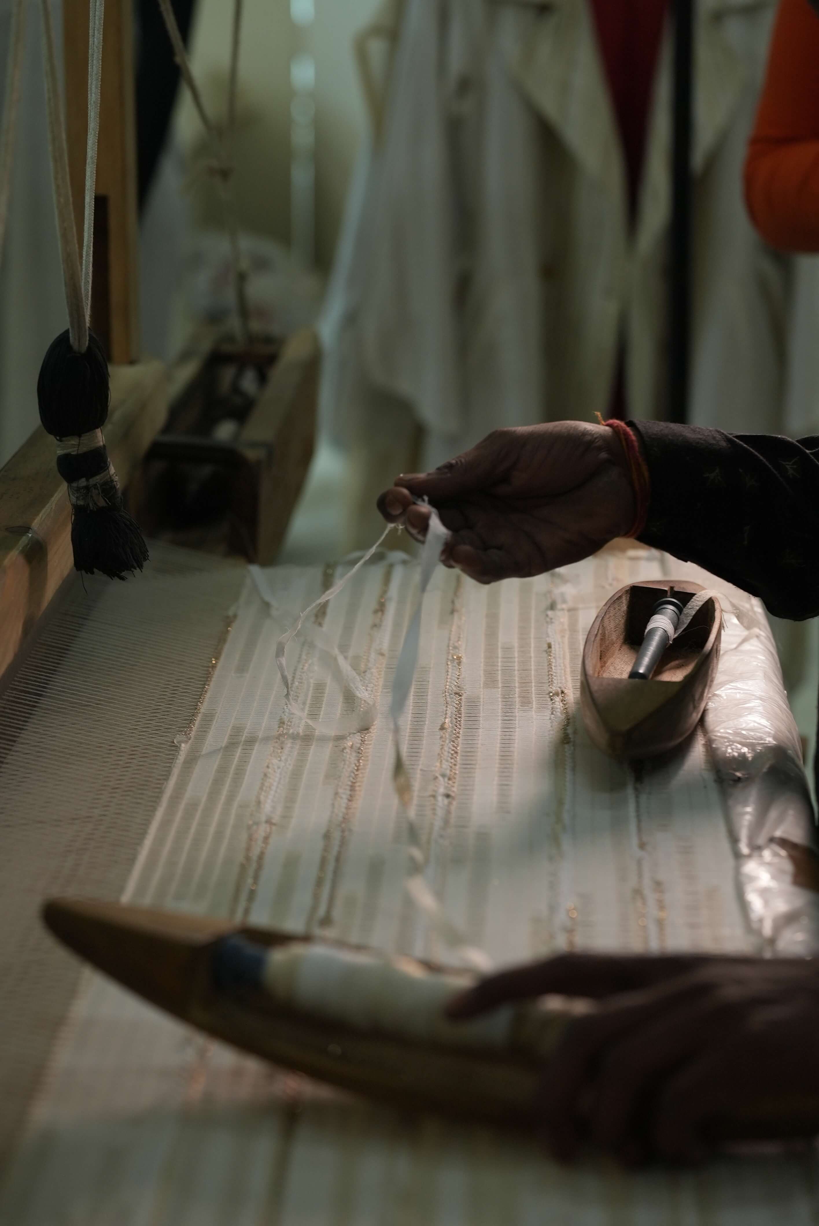 Person working with fabric and tools on a table in a workshop setting for Kashesh Global 
